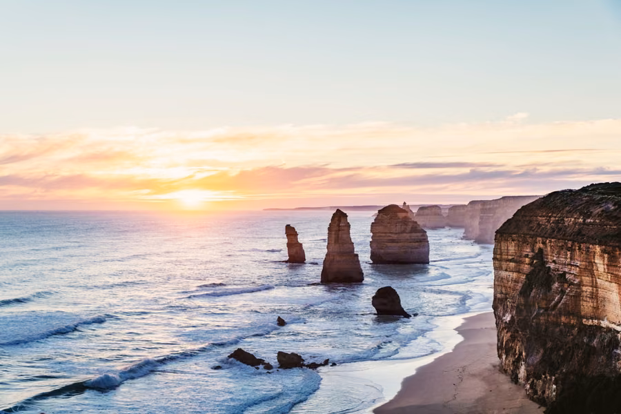 Sunrise over the limestone stacks of the Twelve Apostles and the cliffs of the Great Ocean Road coast