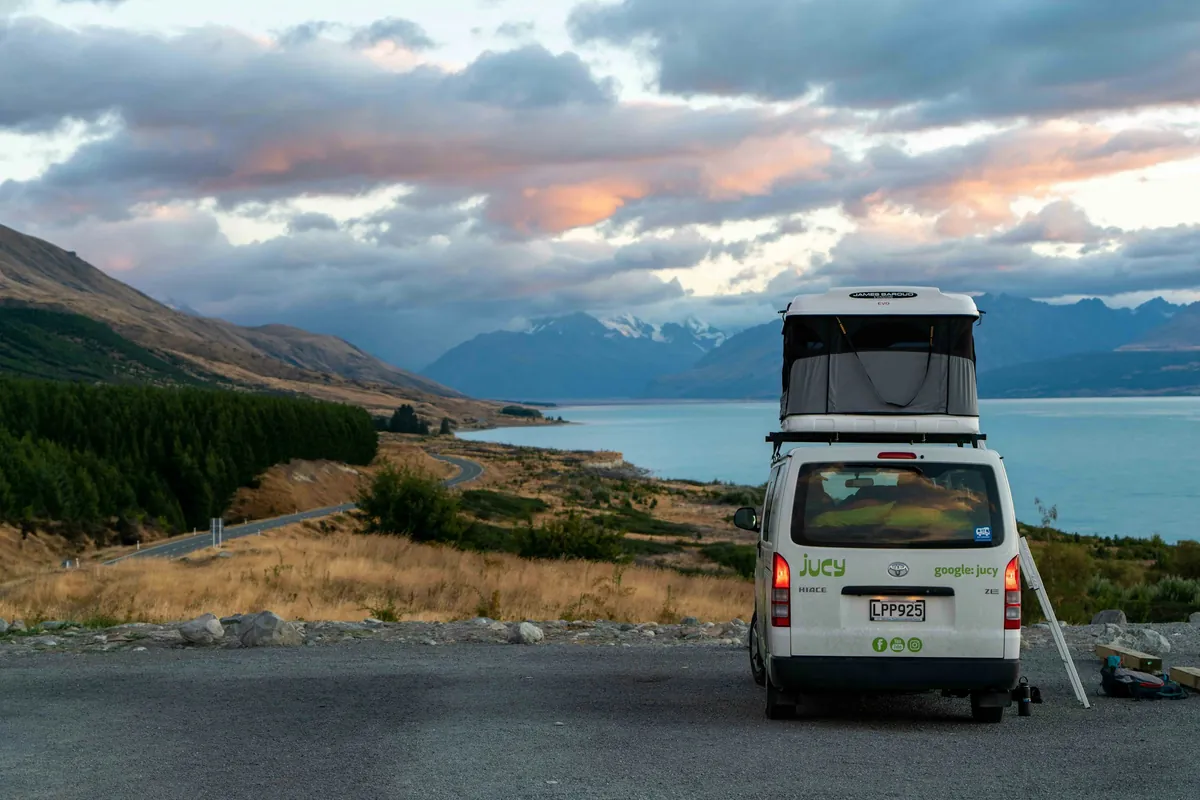Pop-top campervan parked at a roadside lookout above Lake Pukaki