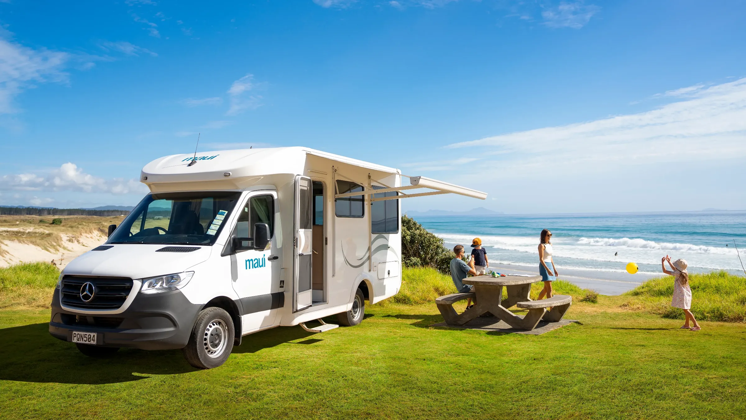 maui Cascade motorhome with awning out beside a beach in New Zealand