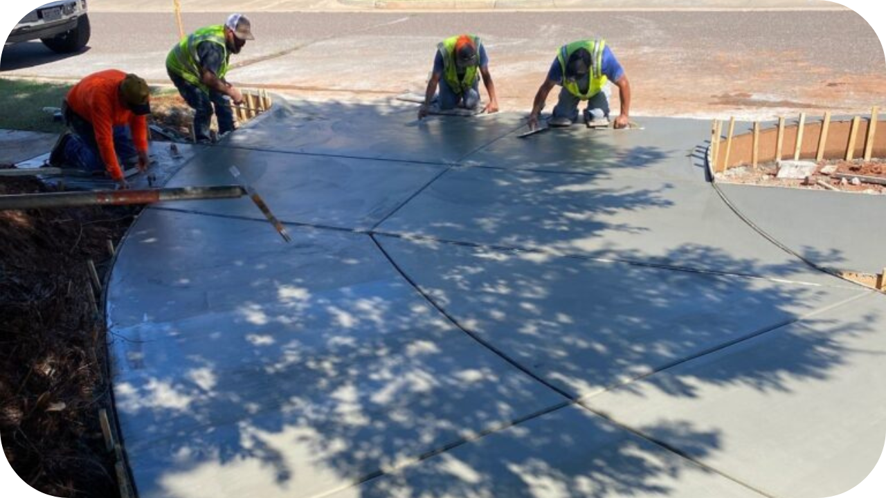 Crew smoothing freshly poured concrete for a curved residential driveway, showing how small job concrete pumping delivers clean, durable results for homeowners.
