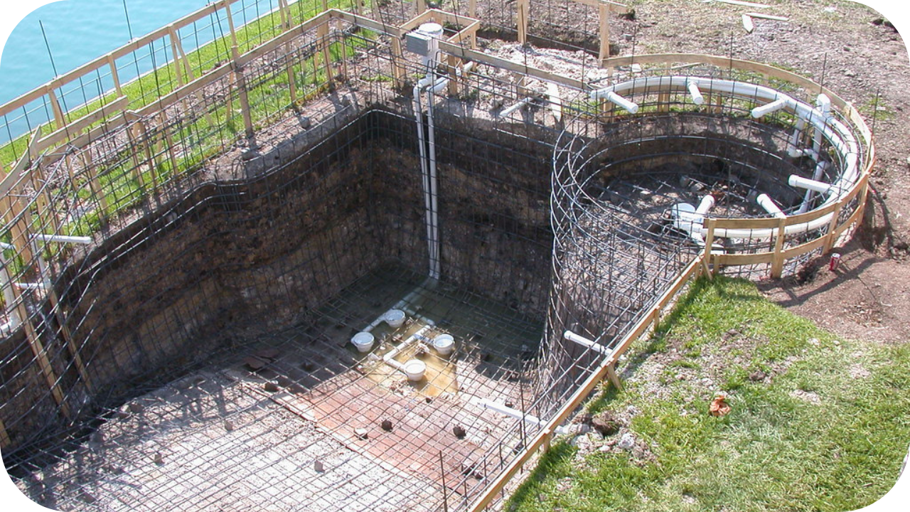 Excavated backyard pool site with steel reinforcement and plumbing in place, showing preparation for small job concrete pumping in residential outdoor projects.