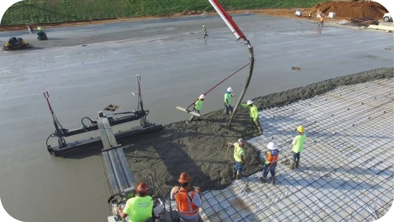 Skilled workers using concrete pumping equipment to place and level concrete evenly across a slab.
