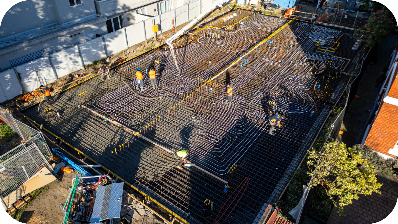 Workers preparing complex reinforced formwork with a boom pump overhead, showing why pumping offers faster precision than traditional concrete pouring methods