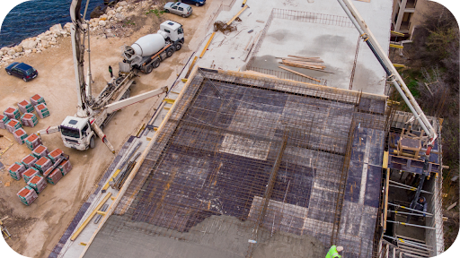Concrete pumps delivering mix to an elevated slab while workers guide the pour, showing efficient pumping methods for multi-level residential construction