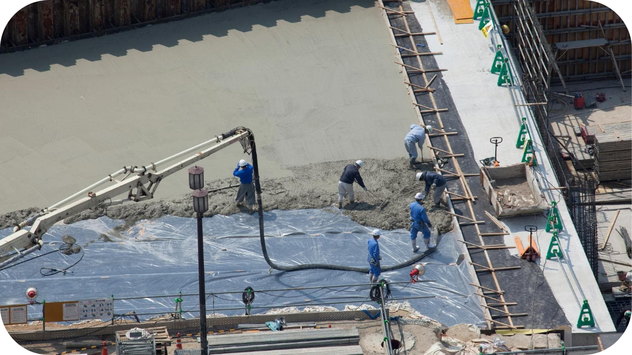 Crew managing pumped concrete across a large footing area while controlling flow and coverage to reduce risks on a complex commercial construction project.