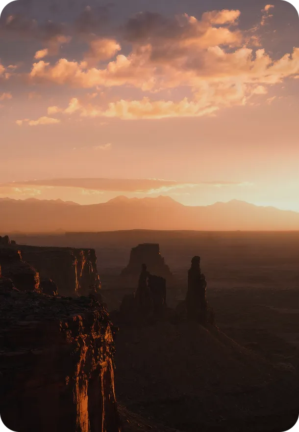 The sun is setting over the canyons in the desert.