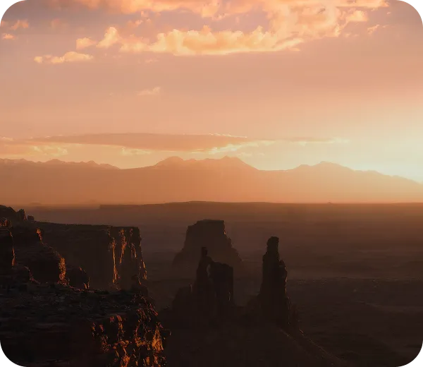 The sun is setting over the mountains in the desert.