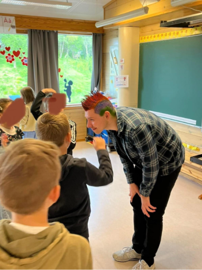 Ivrige elever farger håret til læreren sin som premie under MatteMaraton. Han har en fargerik hanekam.