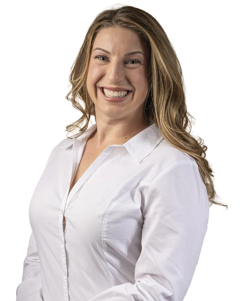 Audiologist with long wavy hair wearing a white button-up shirt.