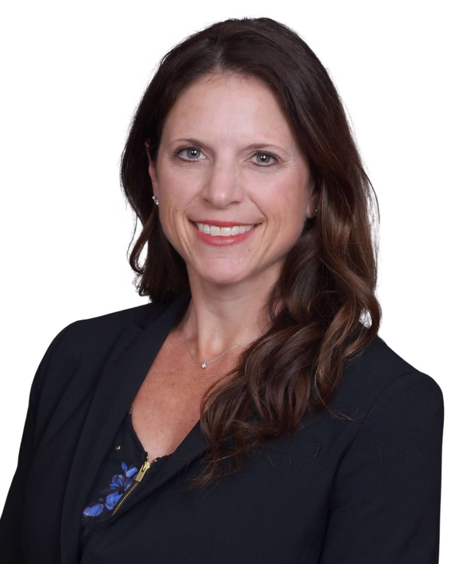 Smiling female audiologist with long brown hair wearing a white top, black cardigan, and heart-shaped necklace.