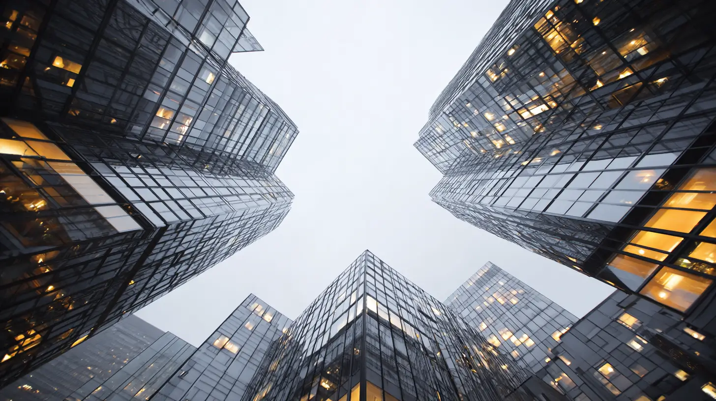 Modernist glass skyscraper viewed from below, illustrating the commercial real estate assets sponsors raise capital to acquire
