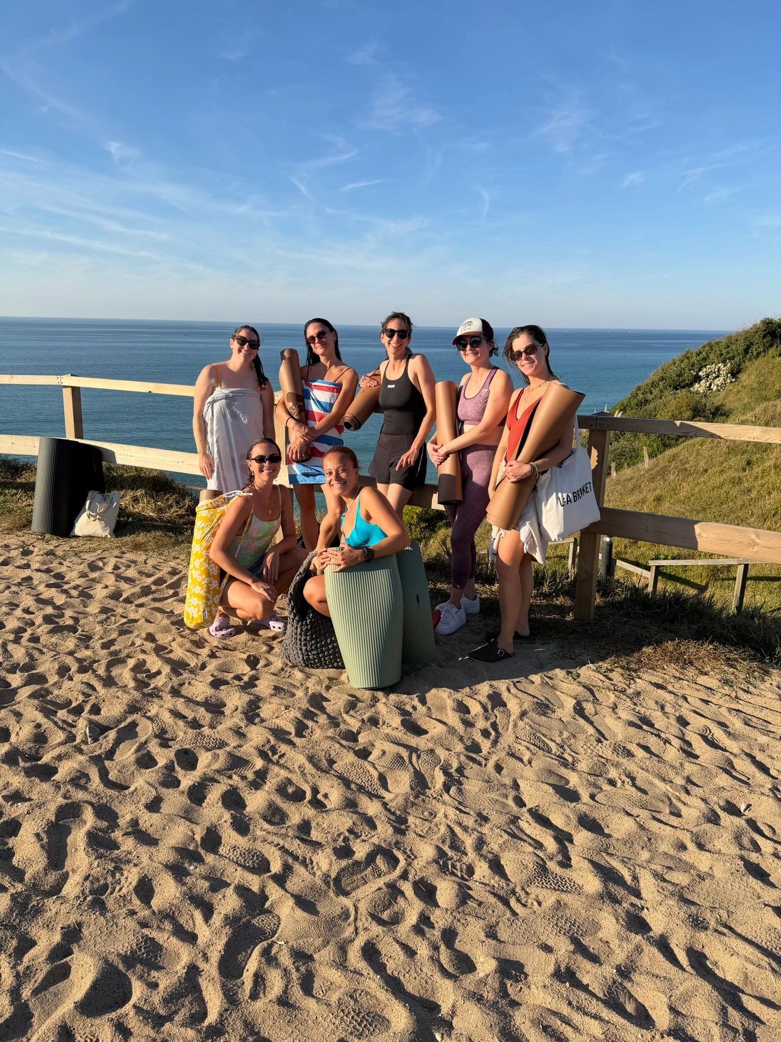 Pilates retreat in a 100% electric campervan with The Family Van - Group of girls on the beach after a Pilates class