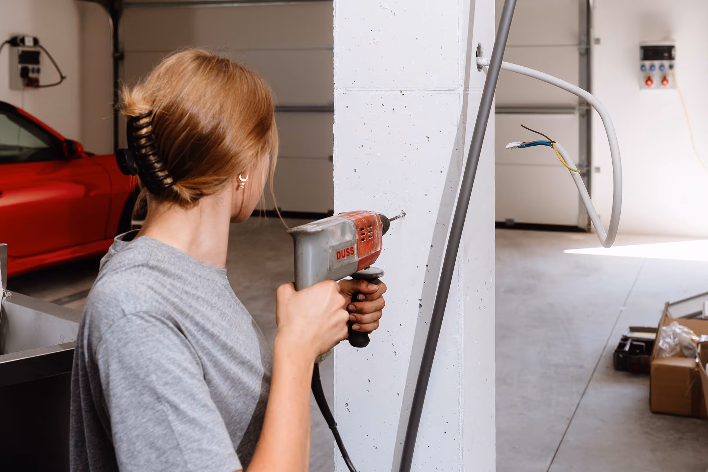 Eine Gühring Mitarbeiterin bohrt ein Loch in einen Betonträger.