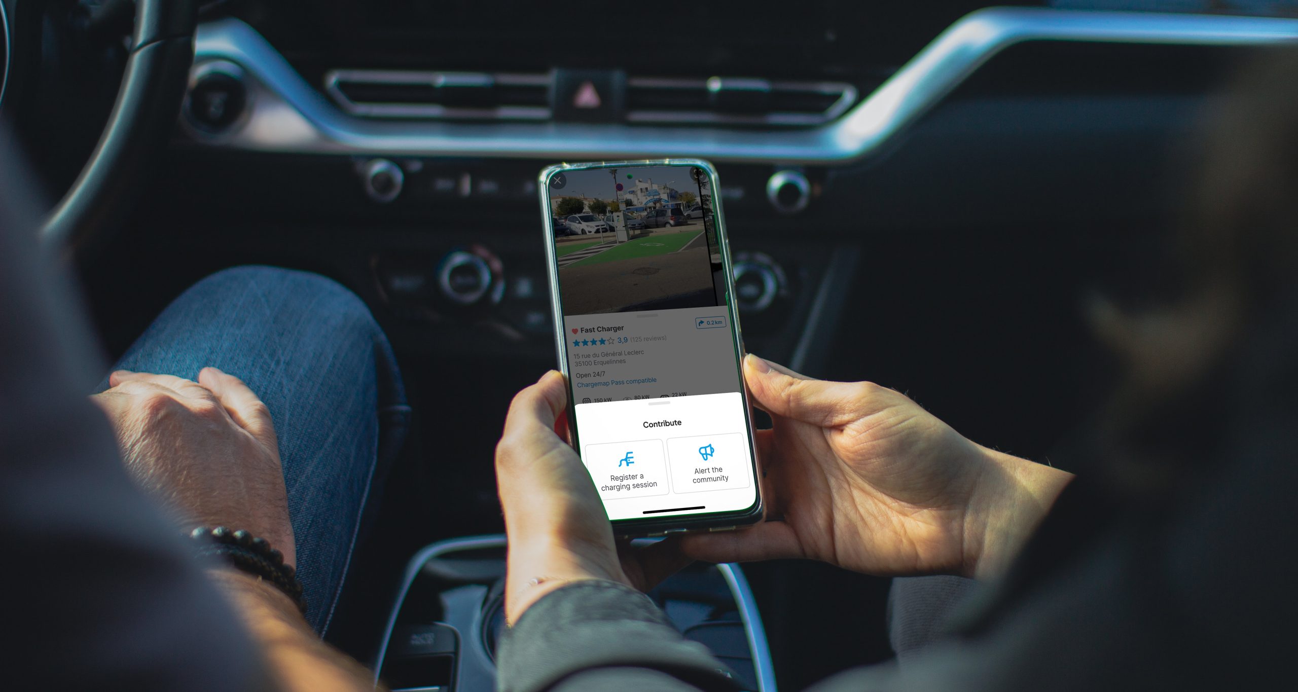 Person in an electric vehicle contributing to the Chargemap mobile application