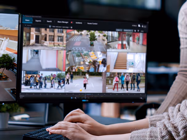Computer monitor displaying multiple security camera feeds monitoring various indoor and outdoor locations.
