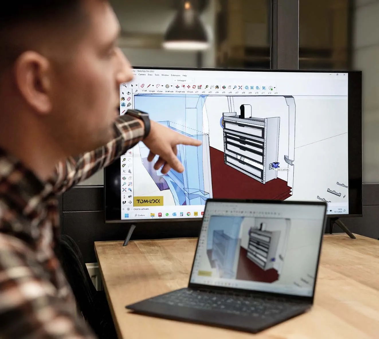 tom-lock dealer wijst op zijn scherm waar een bus wordt ingericht met de tom-lock configurator