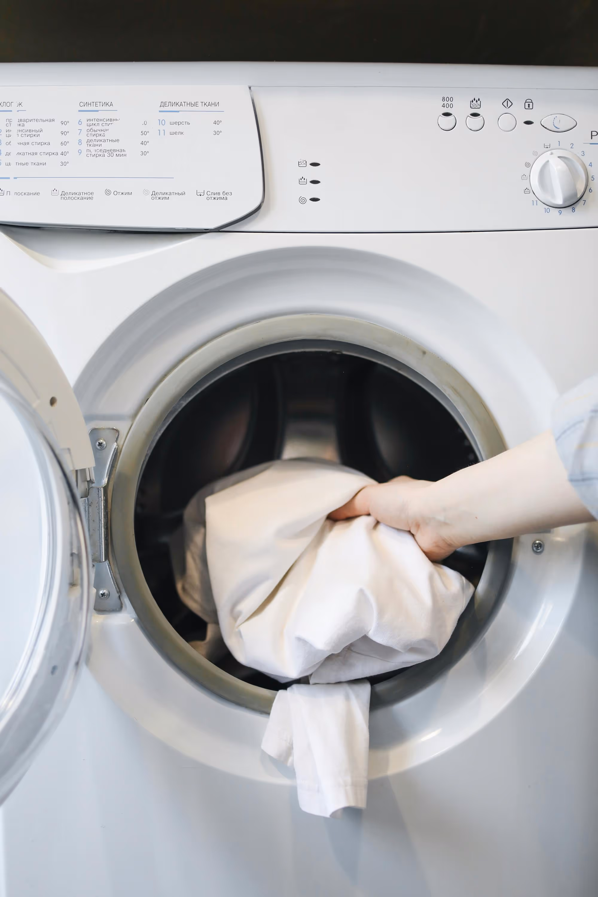 putting clothes in washer stock image