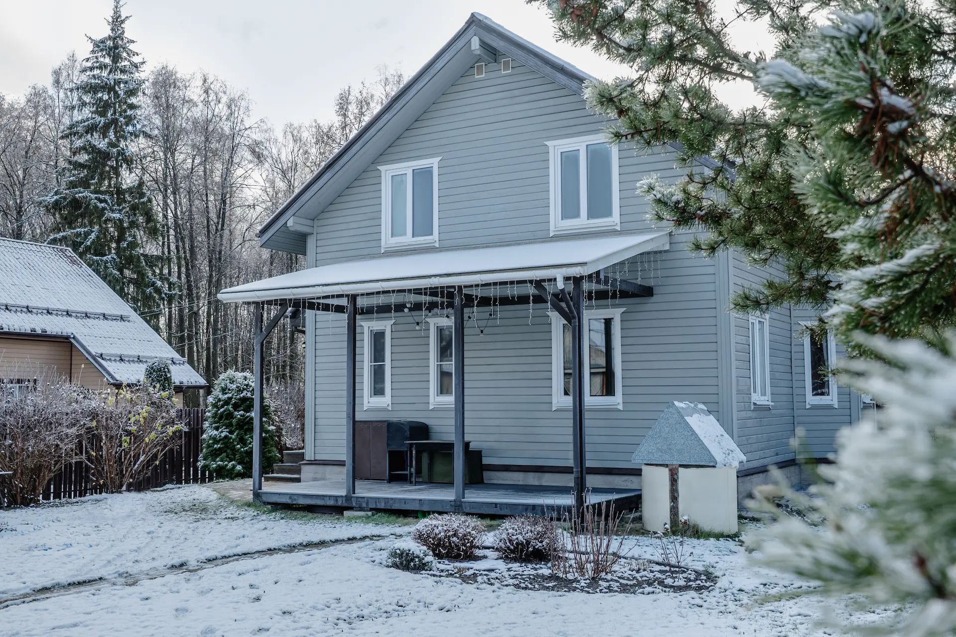 grey house with vinyl siding in the snowy winter