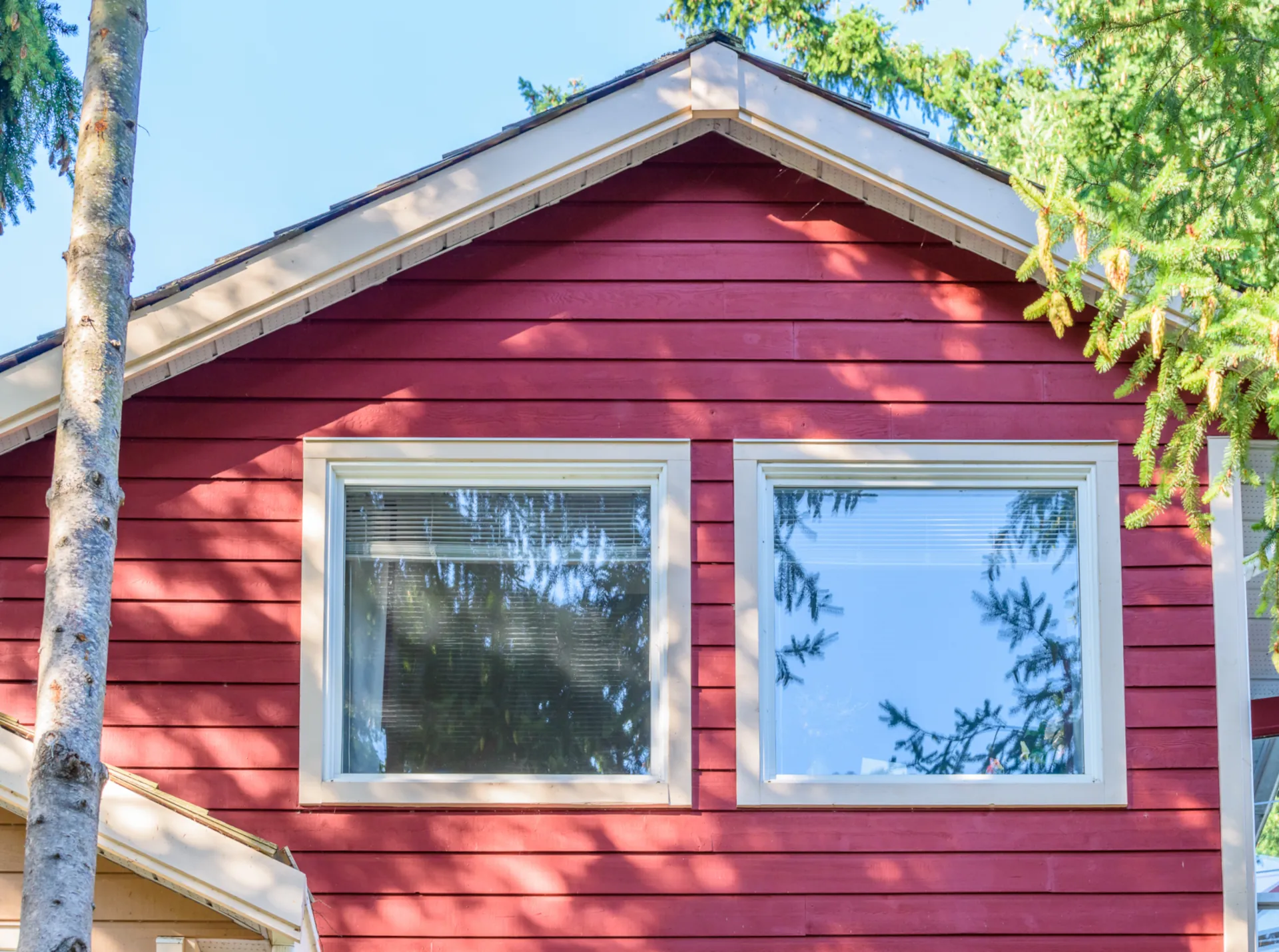the top of a red vinyl siding house with 2 windows