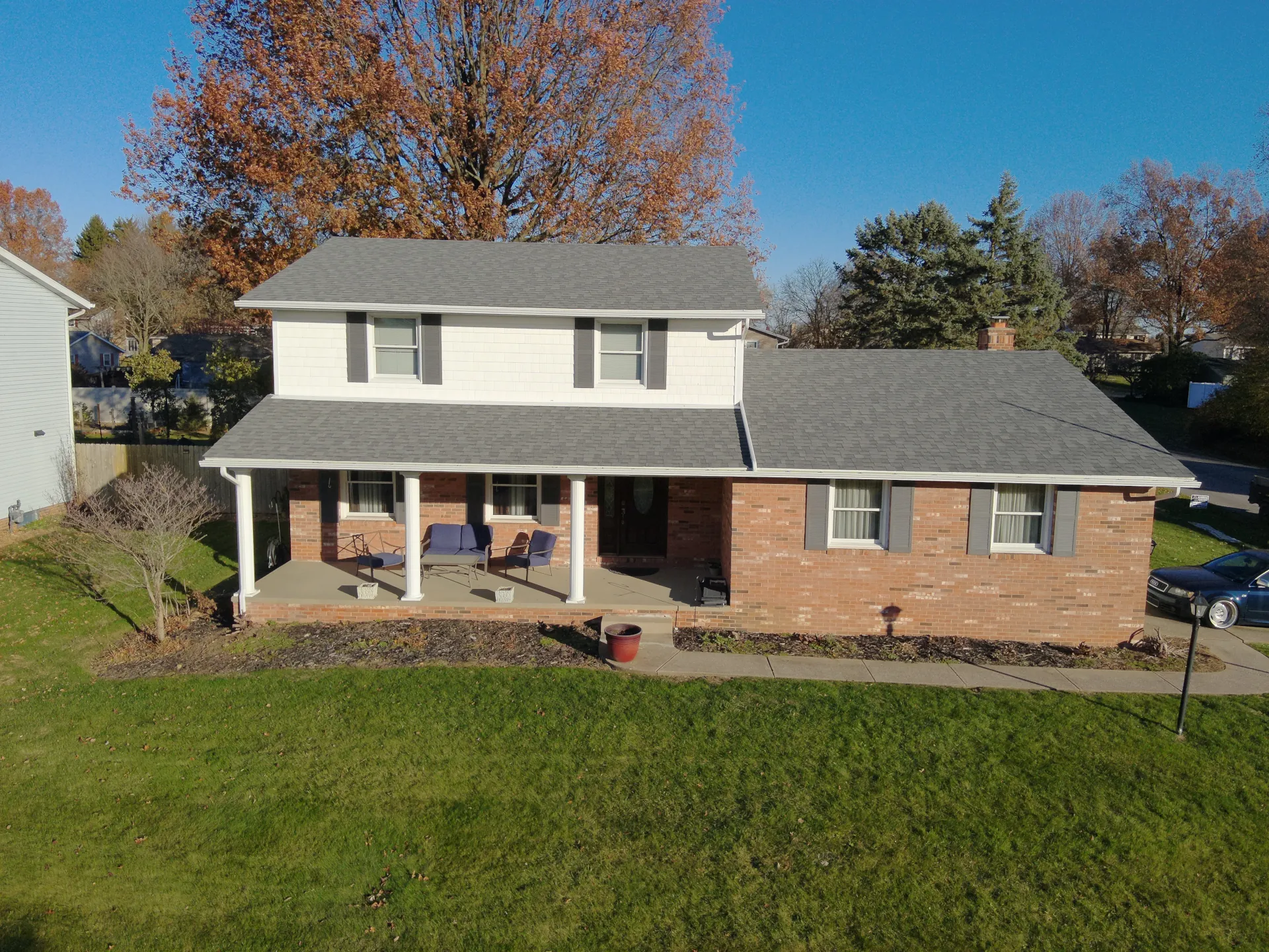 2 story brick house with shingle roofing
