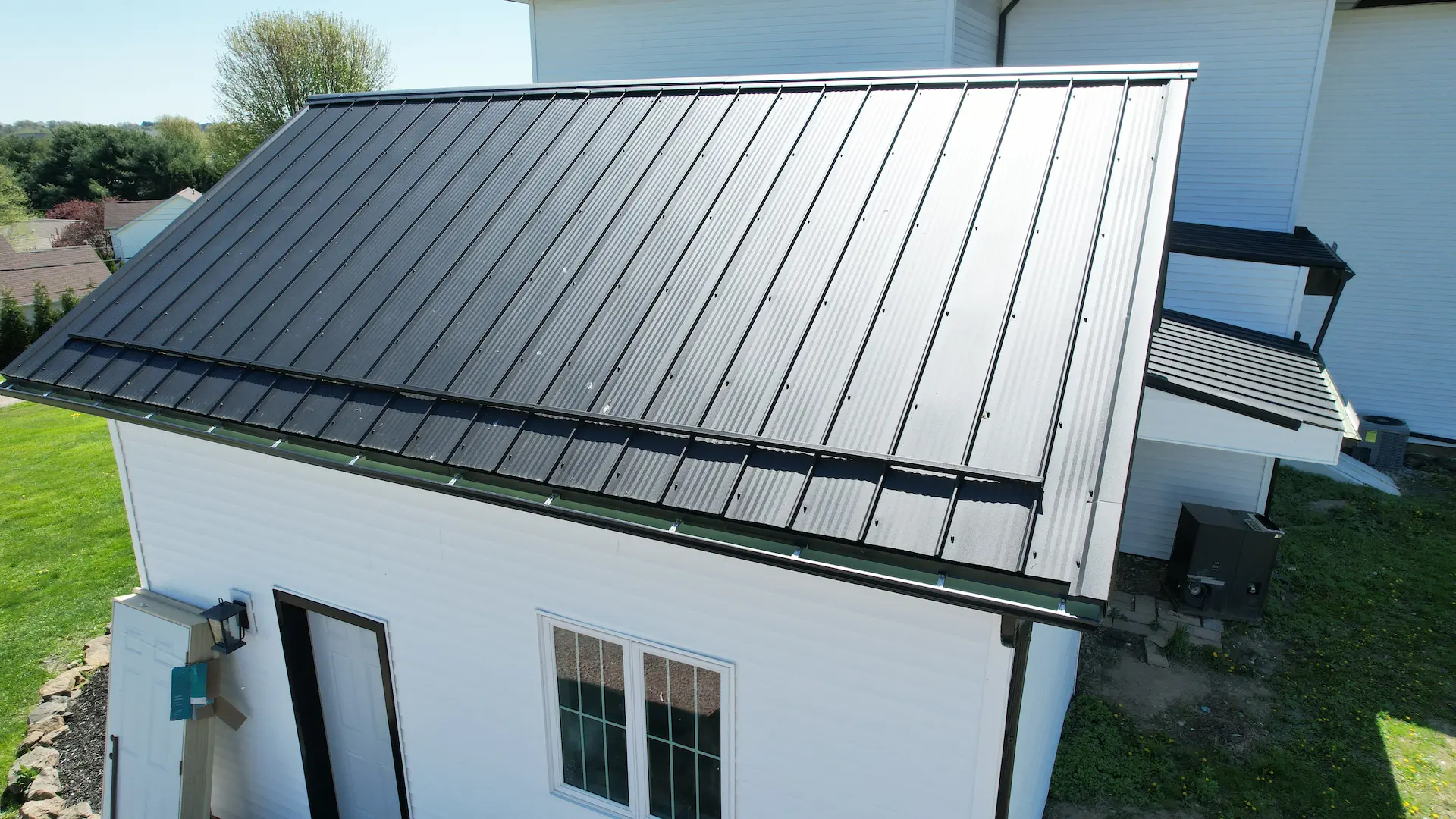 black gutters on a black metal roof of a white house