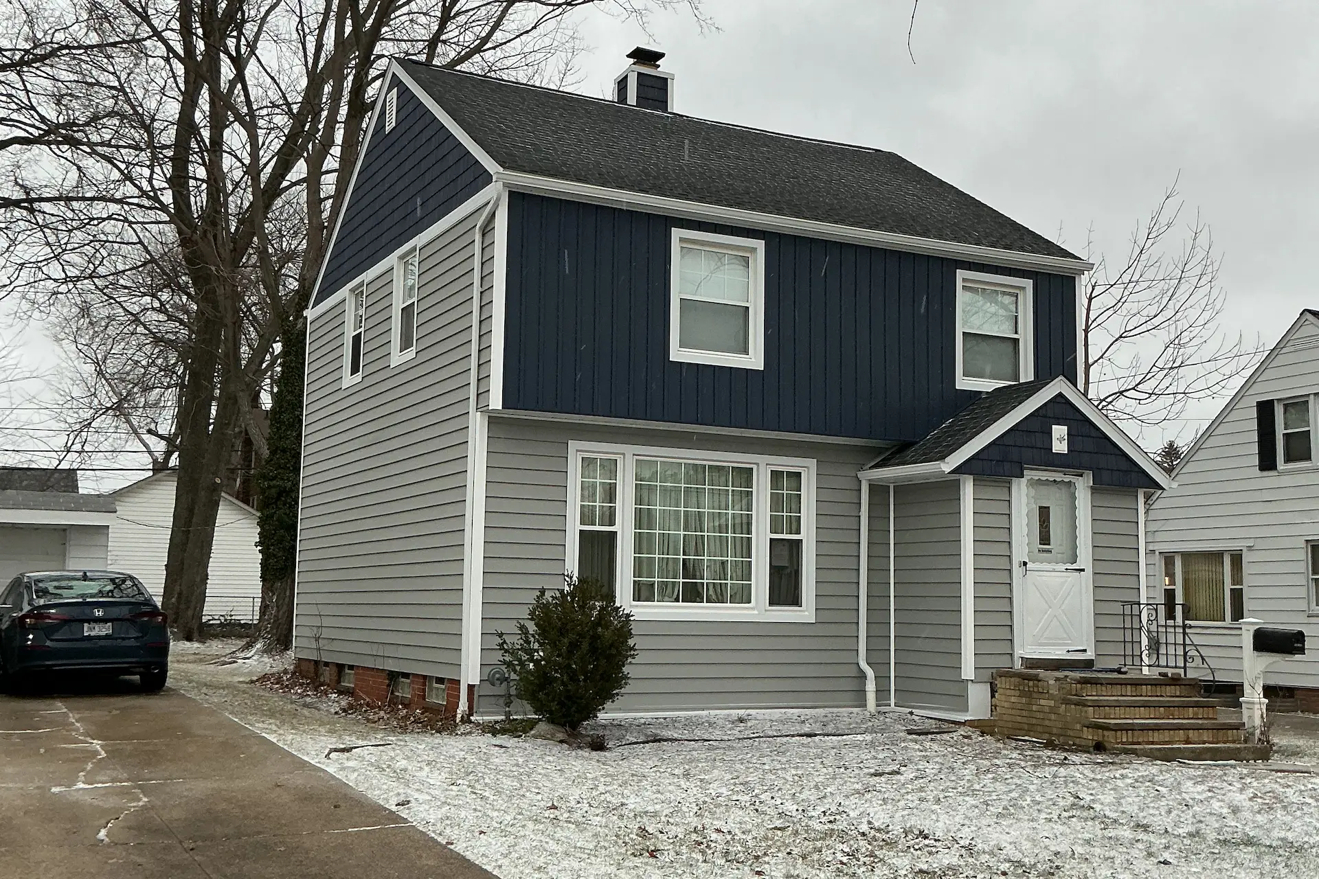 a grey and blue house with vinyl clapboard siding