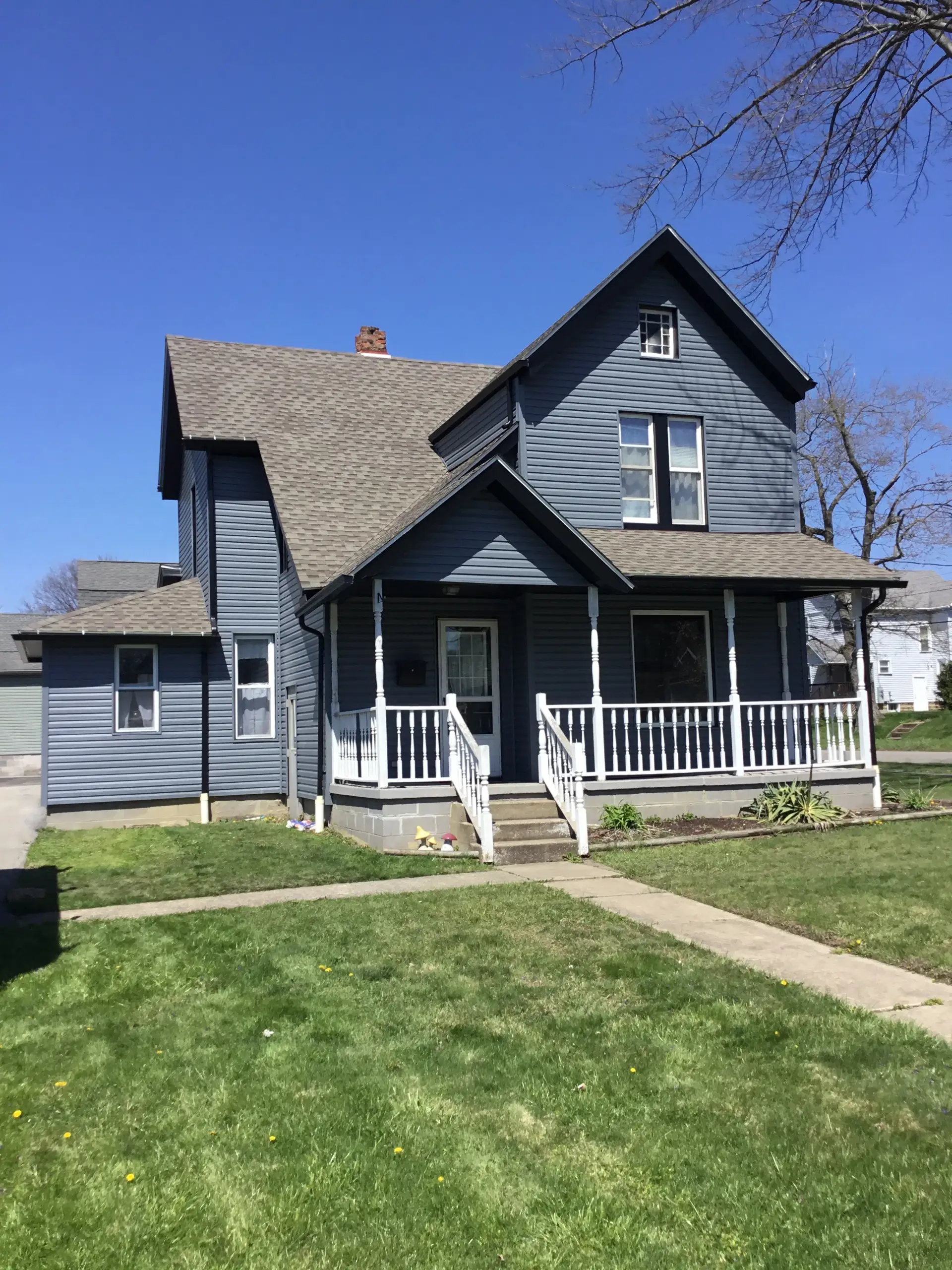 2 story house with blue vinyl siding and lots of windows