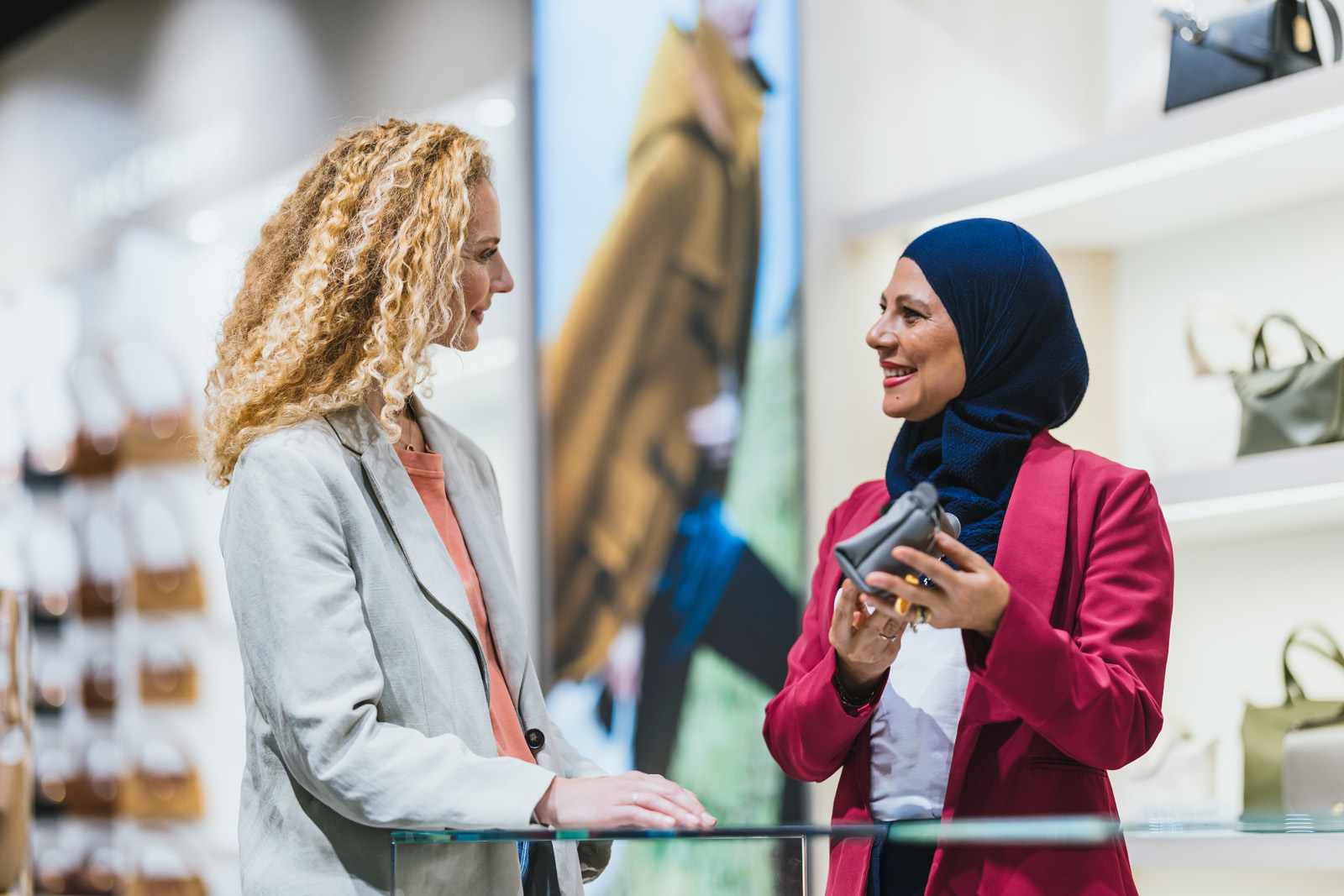 Markenfotografie: Kundin im Gespräch mit einer Verkäuferin in einem Shop am Flughafen München