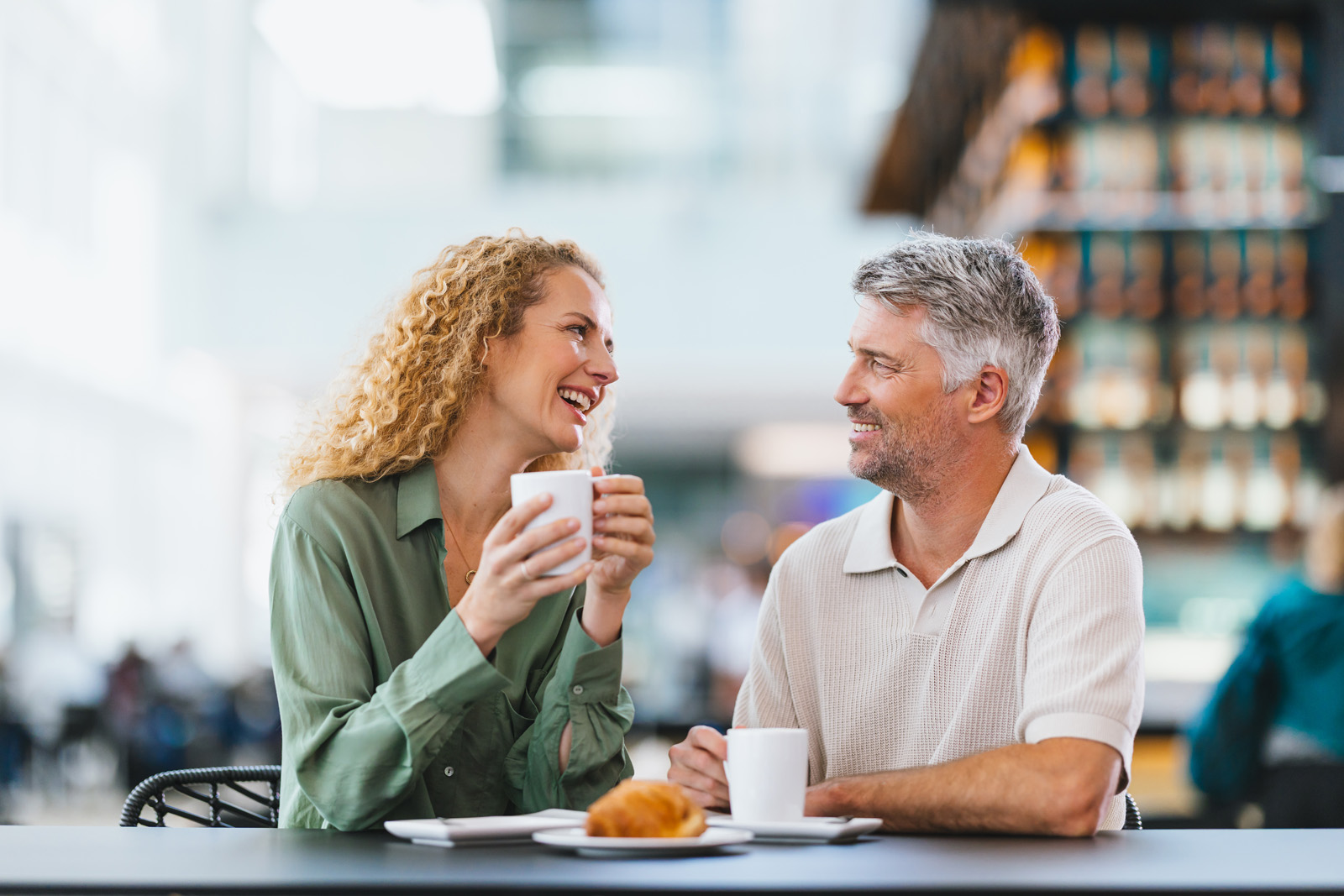 Markenfotografie: Paar genießt Kaffee und Gebäck in einem Café am Flughafen München