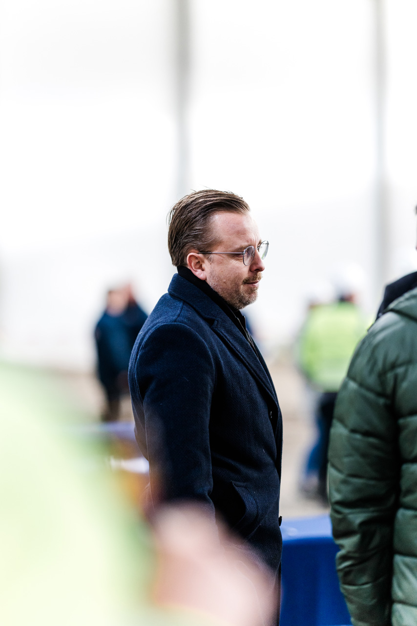 Eventfotografie: Gast im dunklen Mantel beim Richtfest der GARBE Logistikhalle in Leipheim