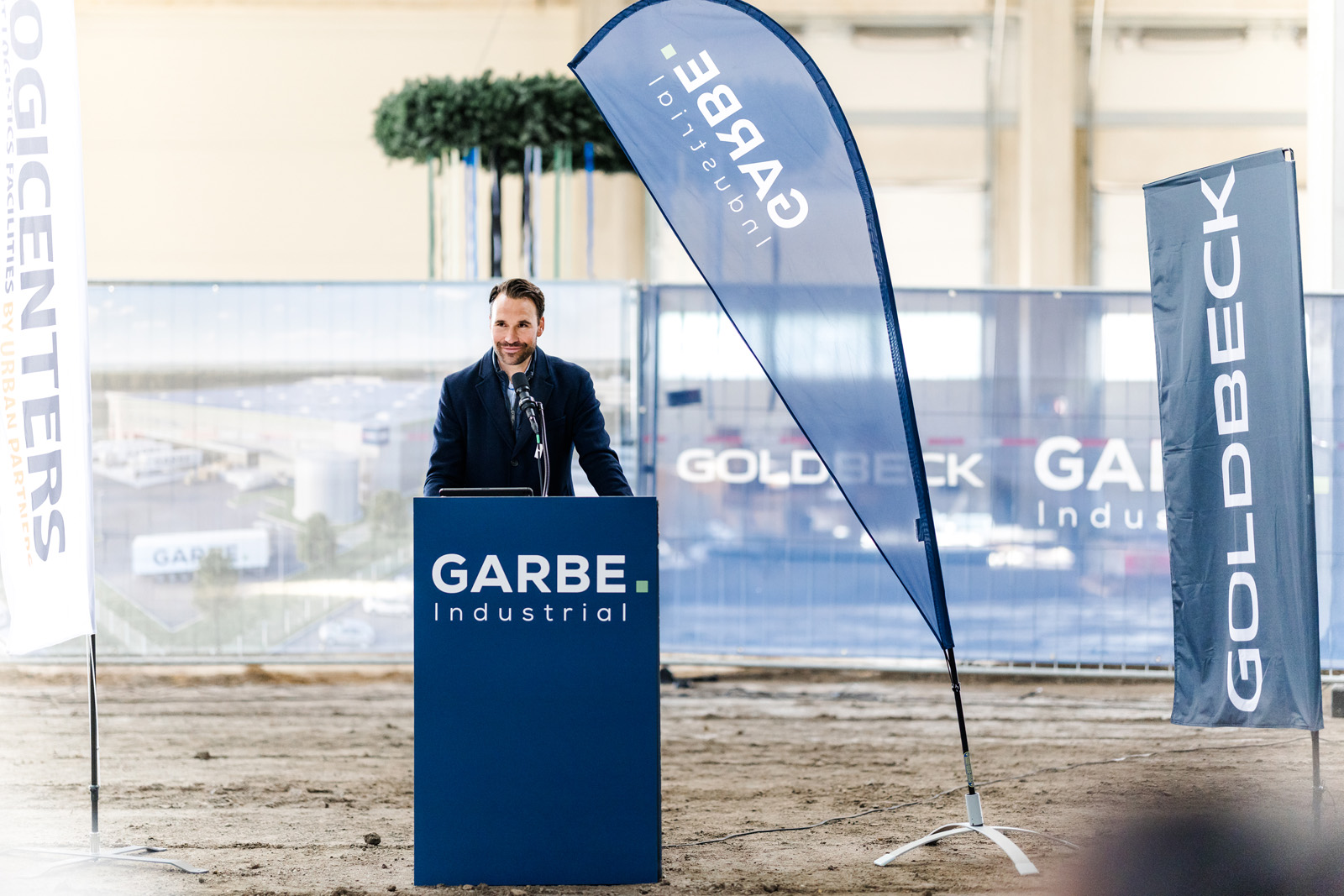 Eventfotografie: Redner am Pult vor GARBE Beachflags beim Richtfest in Leipheim