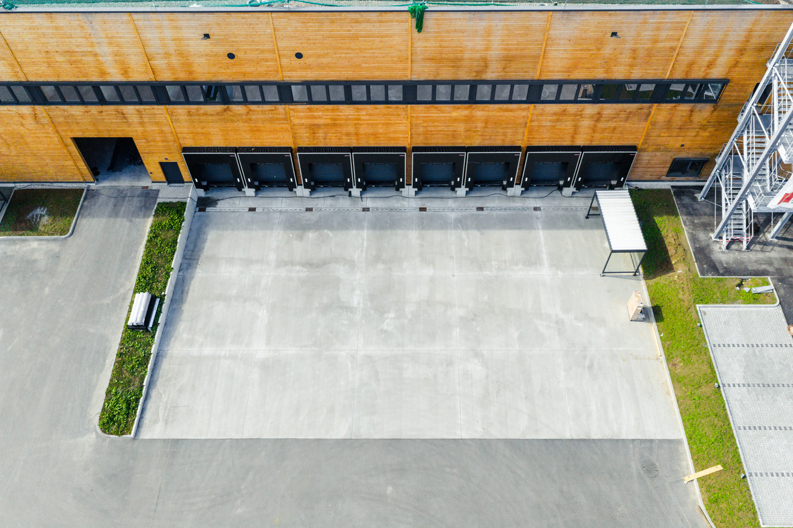 Architekturfotografie: Drohnenaufnahme der Ladezone mit orangefarbener Holzfassade des GARBE Logistikzentrums