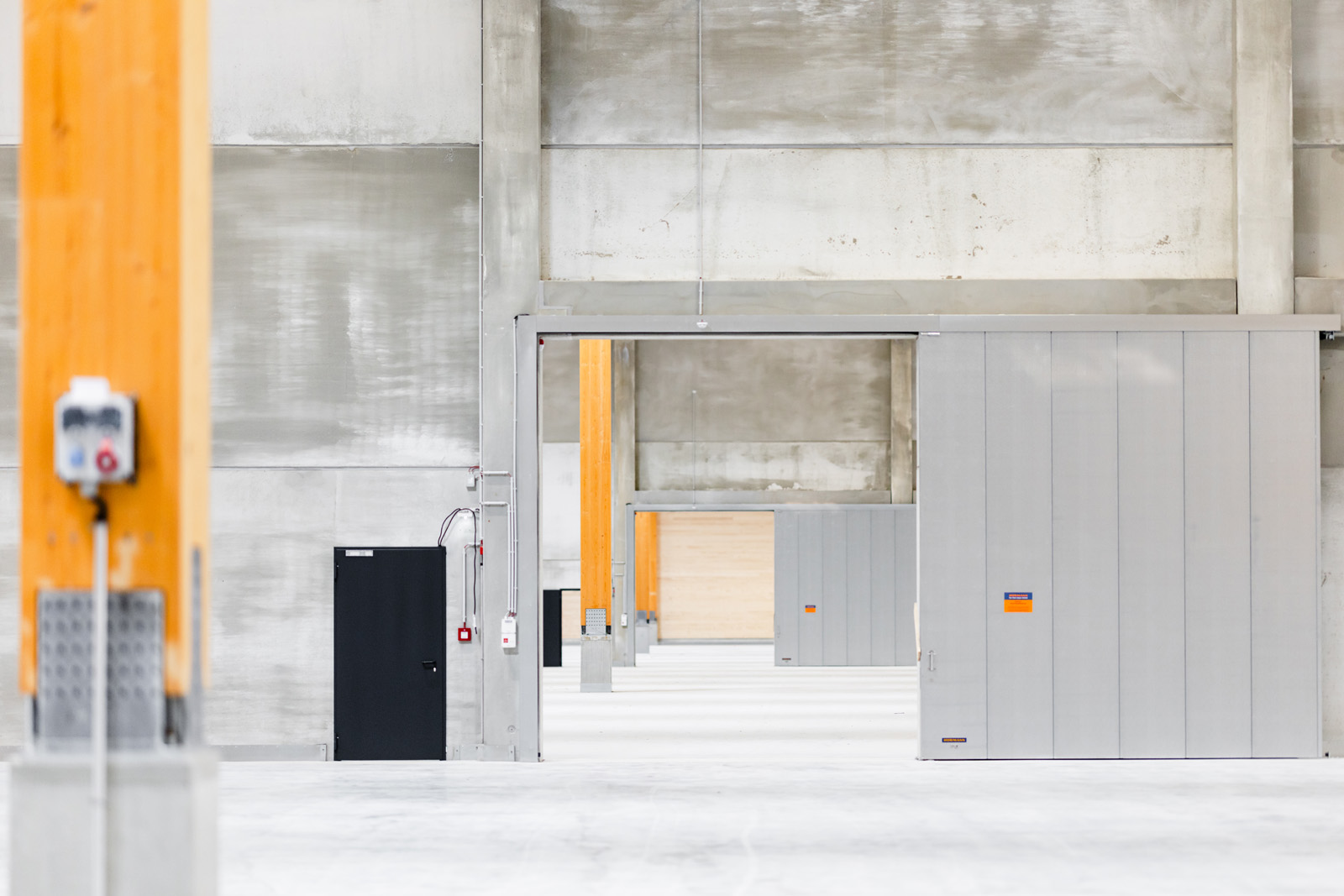 Architekturfotografie: Betonwand und Rolltor im Inneren des GARBE Logistikzentrums aus Holz