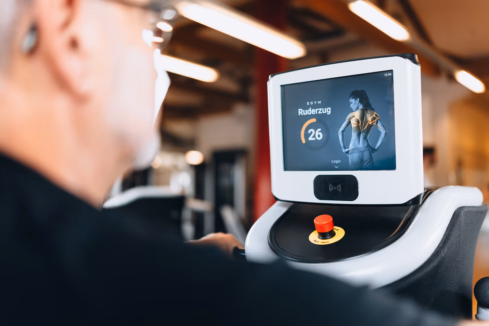 Werbefotografie: Mann bedient den Touchscreen eines Trainingsgeräts im Sportstudio inFORM