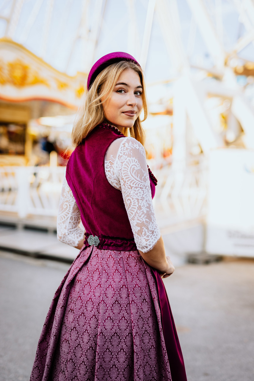 Modefotografie: Junge Frau in einem roten Dirndl und mit weißer Bluse
