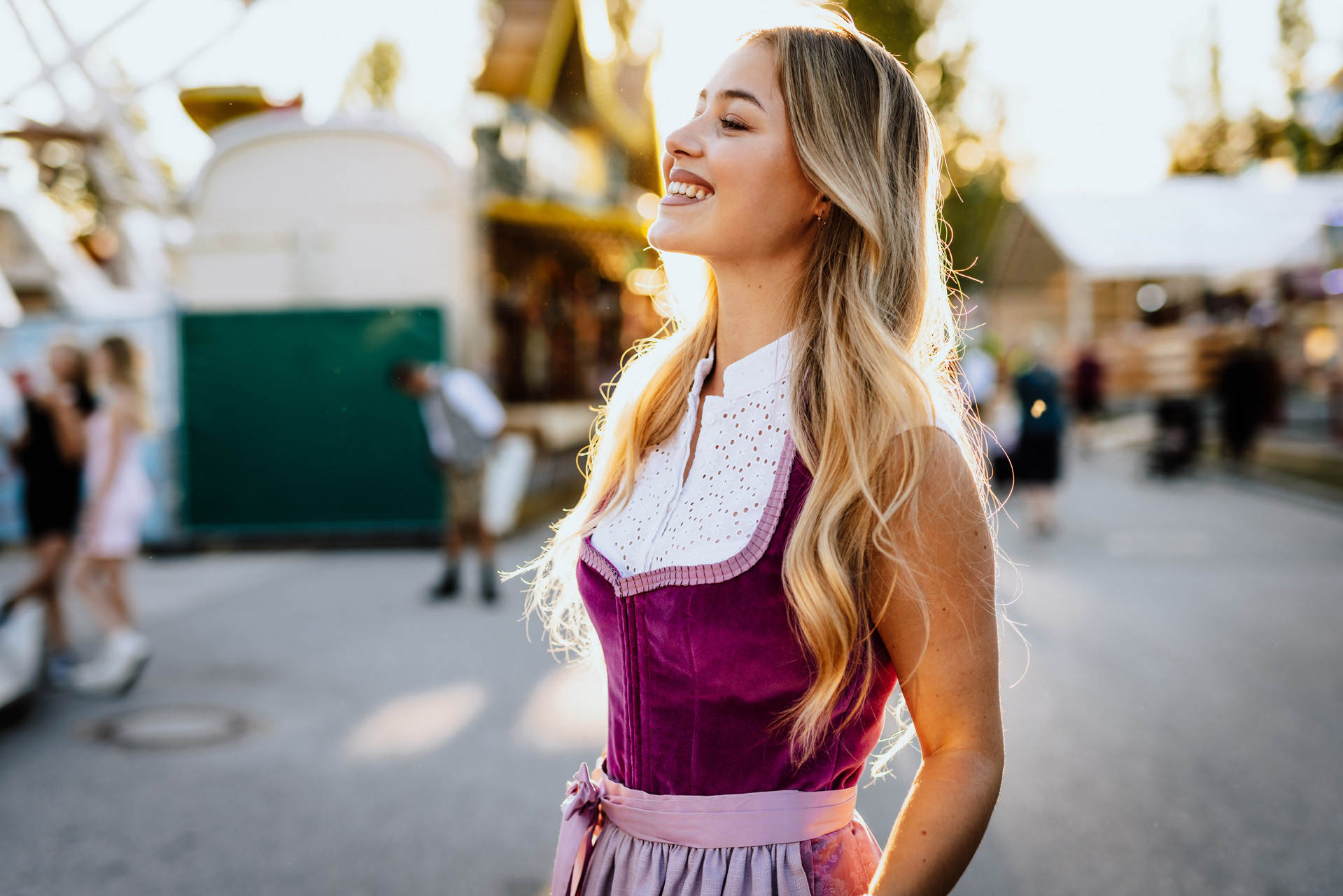 Modefotografie: Junges blondes Mädchen in rotem Dirndl
