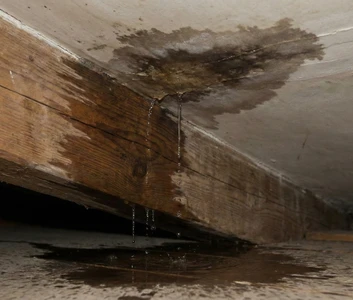 Infiltration d’eau au plafond et sur une poutre de charpente dans les combles après fuite de toiture à Carros