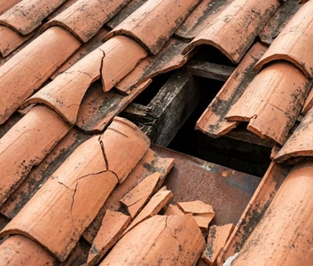 Tuiles romanes cassées et déplacées par le vent sur une toiture à Nice nécessitant une intervention.