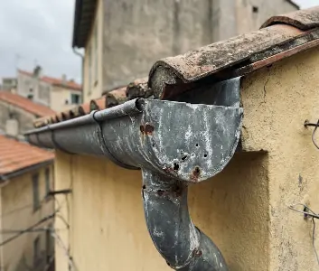 Gouttière zinc corrodée par l'air salin à Menton, perforée en surface après deux étés sans traitement hydrofuge.