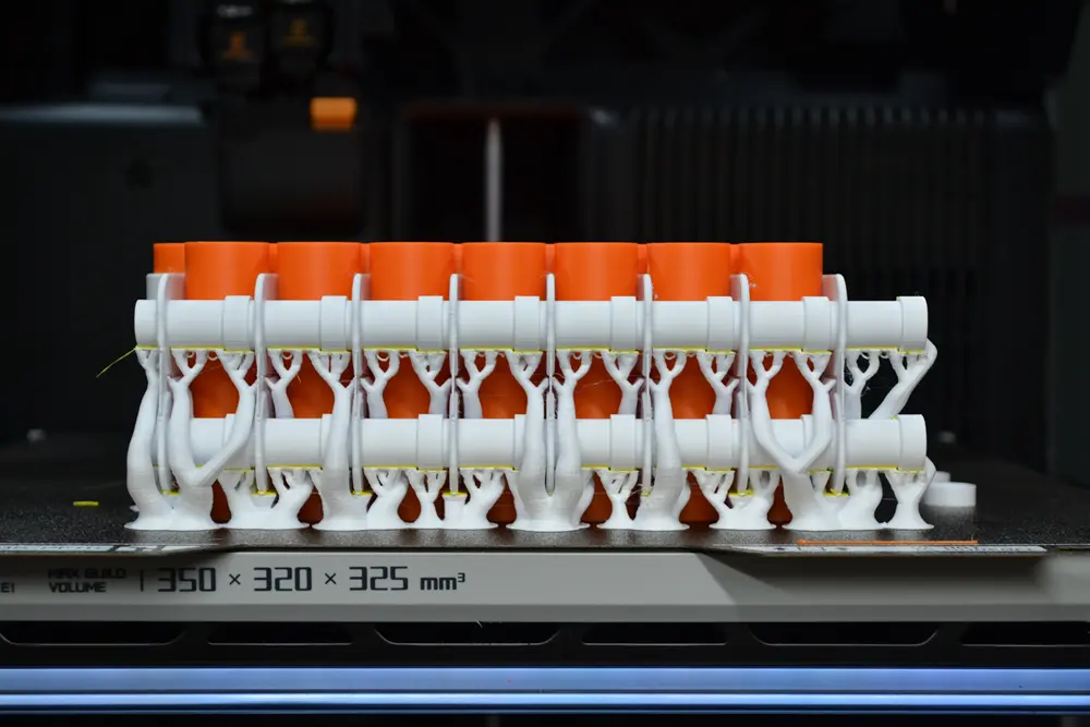 Batch of resin 3D printed parts on the build plate of a large format printer at Nexform