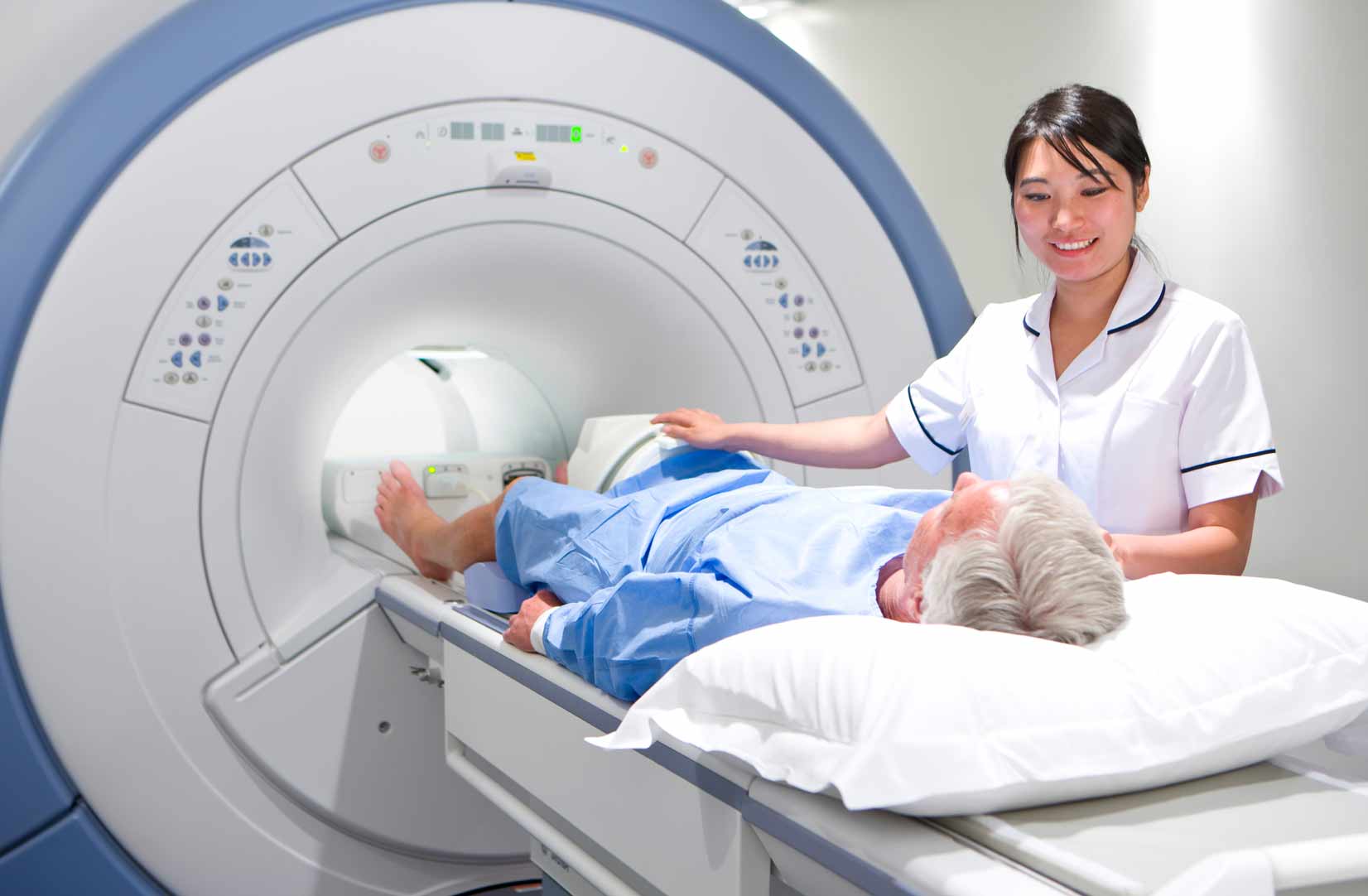 a patent going into an MRI scanning machine with a nurse stood next to him