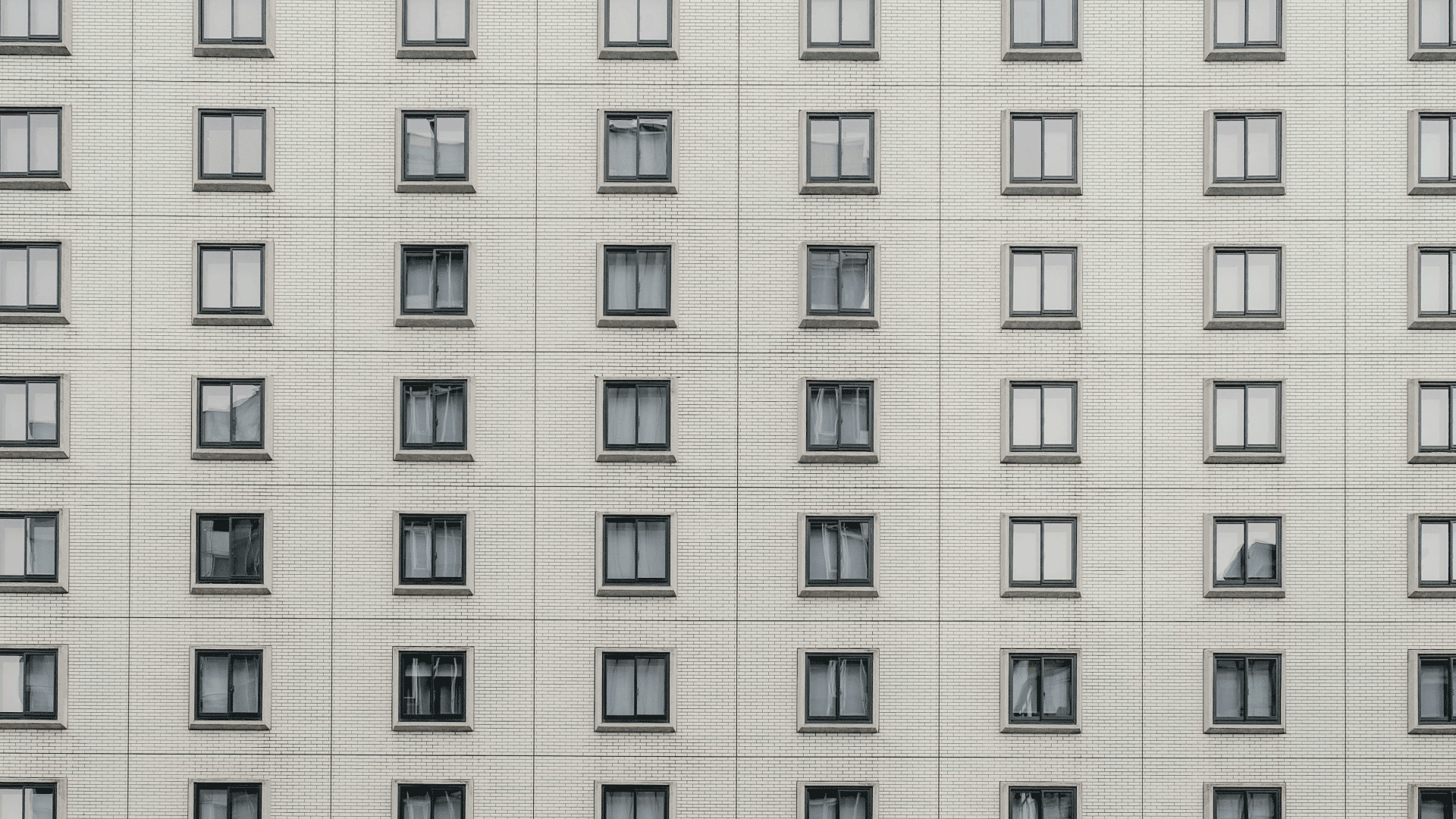 A gray building wall filled with windows