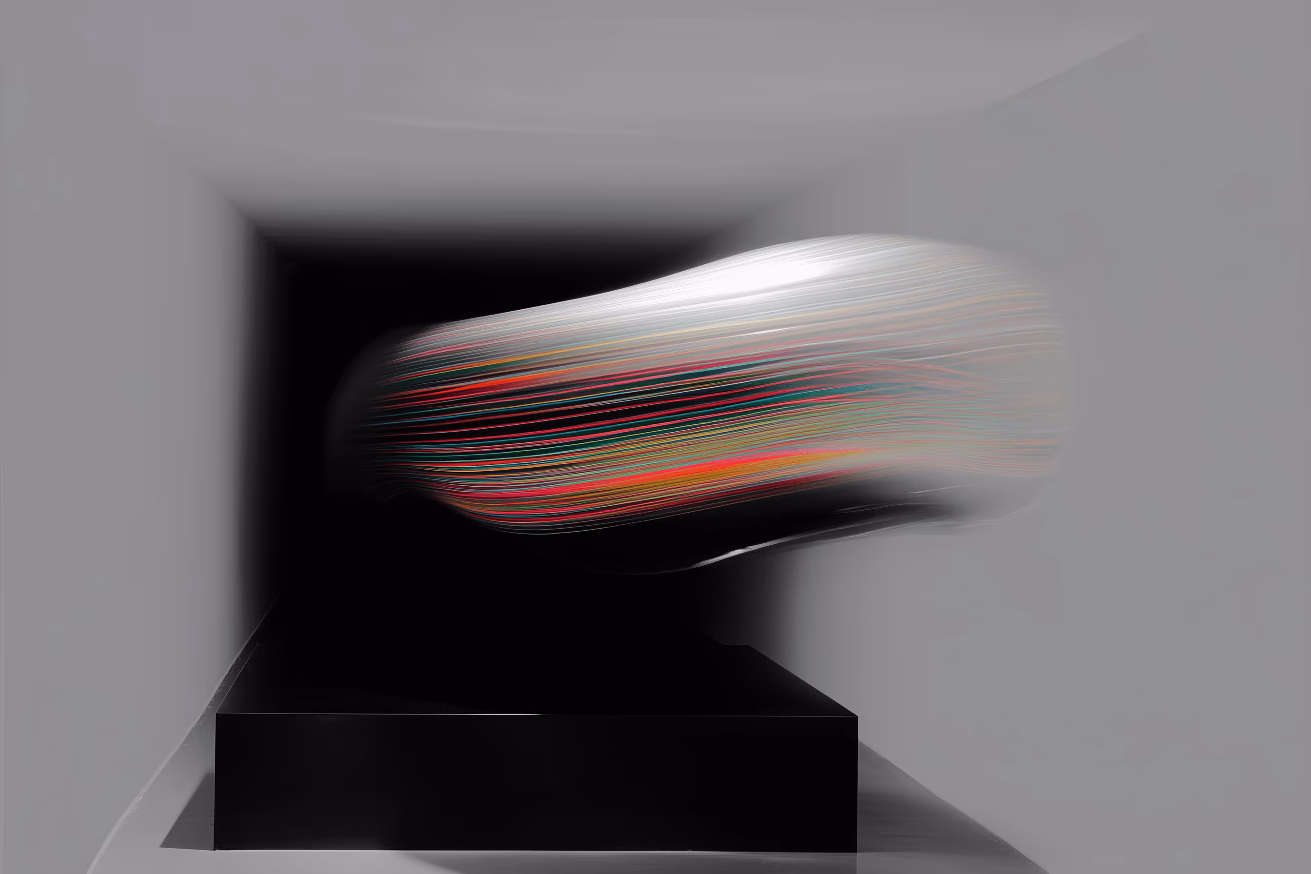 Abstract sculpture featuring a metallic, elongated shape with multicolored horizontal lines, mounted on a black platform in a minimalistic gray room.