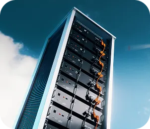 Tall, outdoor battery storage unit with multiple connected black battery cells against a blue sky with clouds.