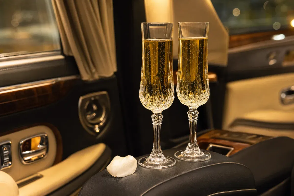 Champagner im Hochzeitsauto Frankfurt – zwei Kristallgläser auf Leder-Armlehne in Luxuslimousine