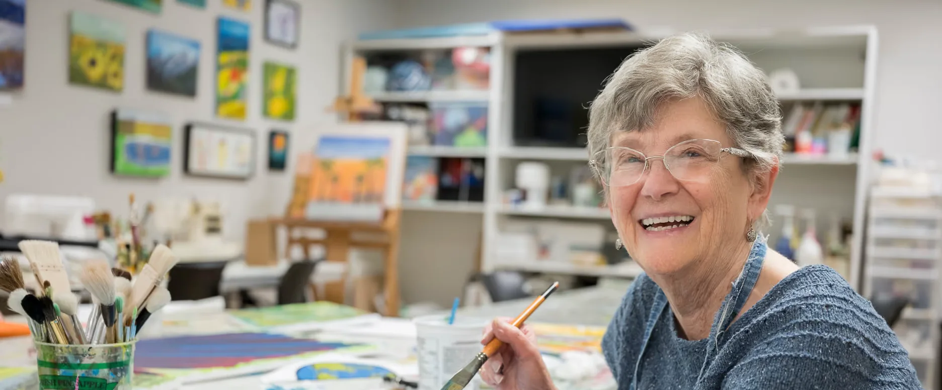 Smiling resident painting in an art studio