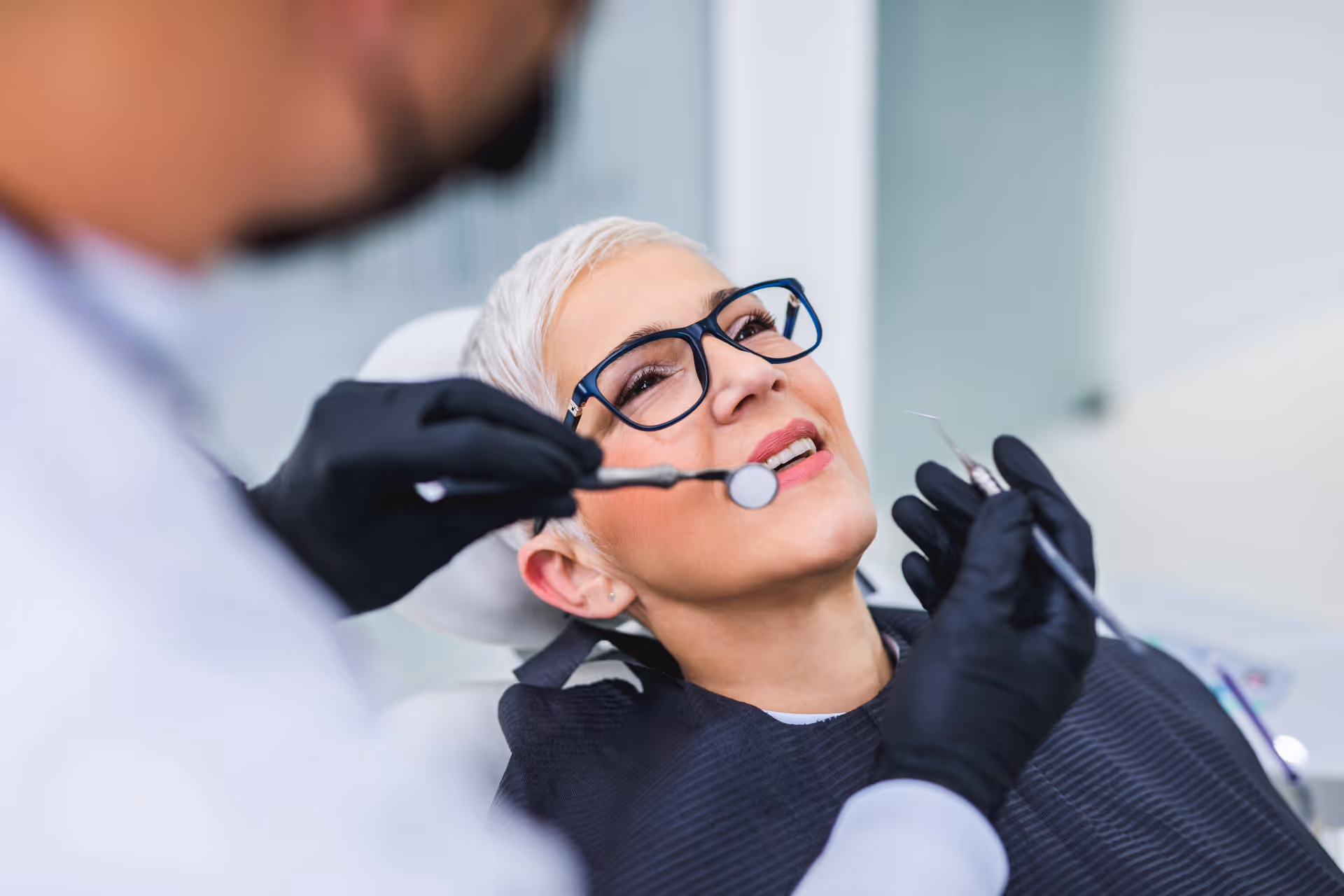 Beautiful senior woman having dental treatment at dentist's office