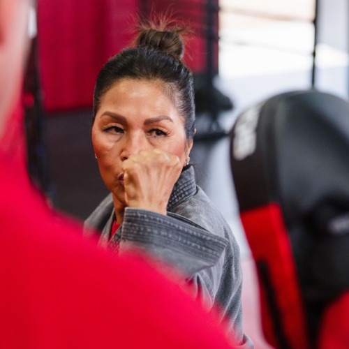 Woman in karate gi participating in Self Defense Class.