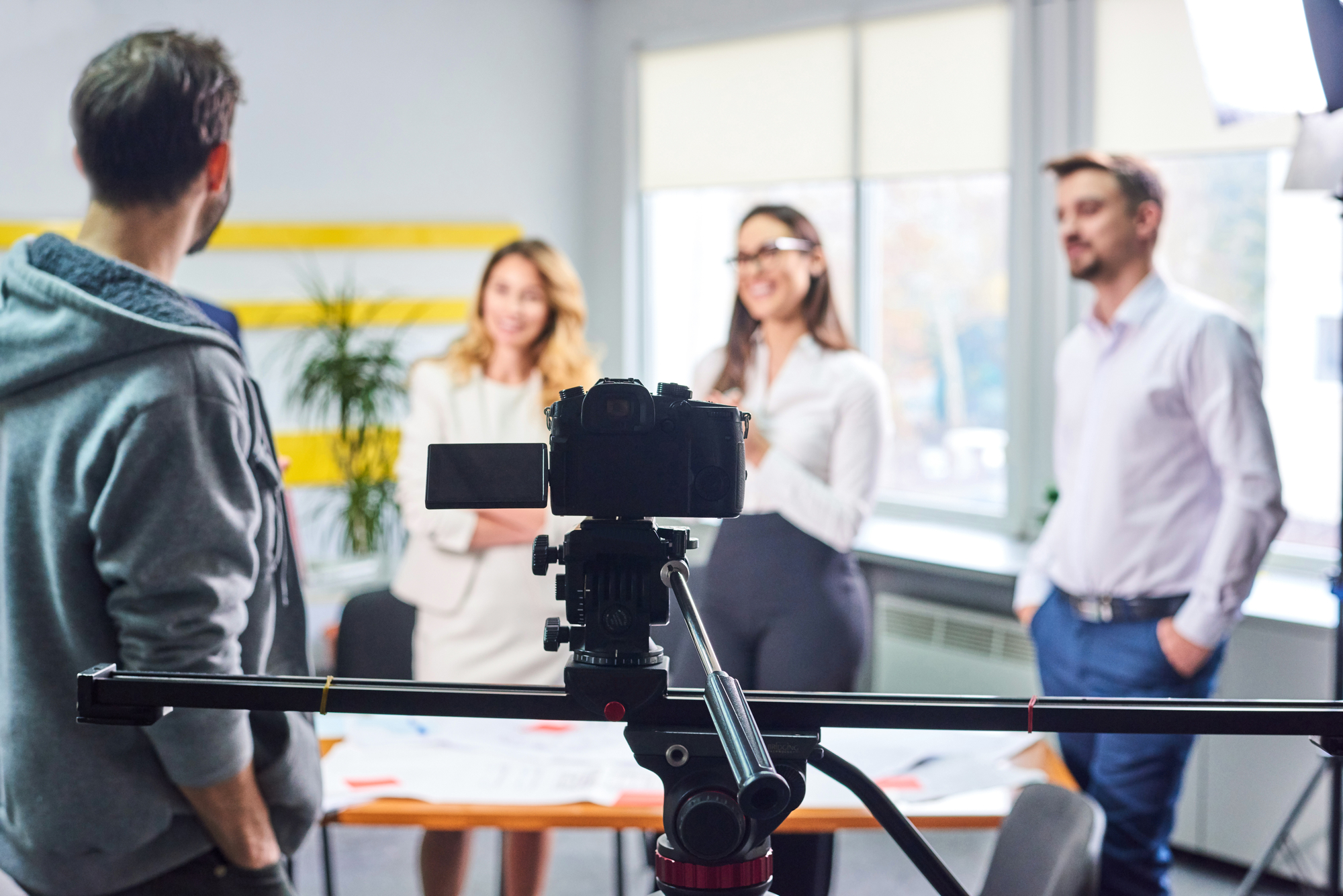 A group of people standing around a camera.