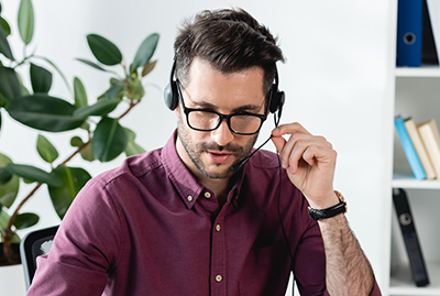A man sitting at a desk wearing headphones.